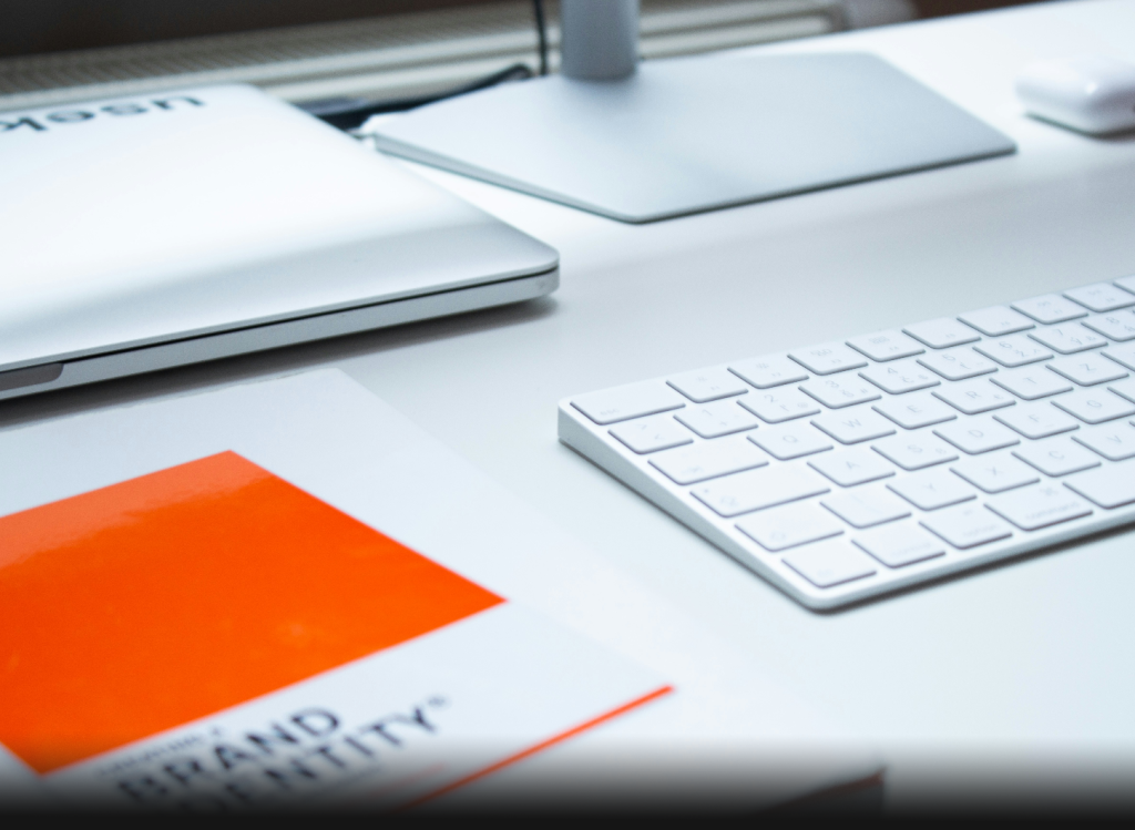 a keyboard, laptop and base of monitor stand